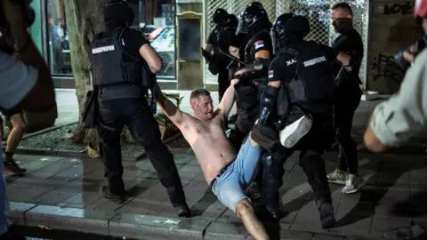 Serbia police clash with protesters calling for early election Reuters Law enforcement officers detain a demonstrator in Belgrade