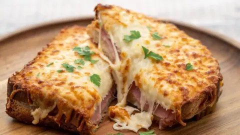 Japanese fruit sando hits high streets Clubfoto/Getty Images A croque monsieur, a sandwich with toasted bread, ham, and melted cheese on top with parsley, in served on wooden plate