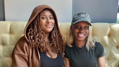 Be ready to be shocked and offended at university, students told Hope Rhodes / BBC Two young black women sit in a booth at a bar smiling at the camera. Paris on the left wears a brown hoodie and Marie-Louise on the right wears a grey baseball cap.