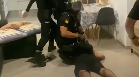 48 arrested in international cocaine gang bust Europol A police officer kneeling on the back of a suspect as they are arrested