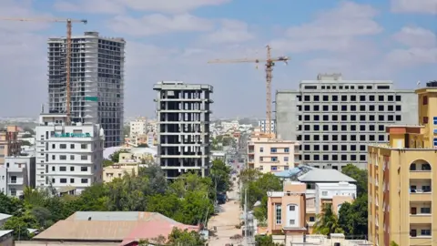 Somalia's construction boom in Mogadishu gives women high ambitions Mohamud Abdisamad / BBC Mogadishu's skyline showing multi-storey buildings under construction and several cranes.