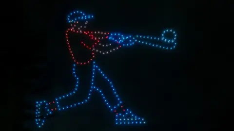 Will they overtake firework displays? Chris J Evans An outline of a baseball player hitting a ball, made be drones
