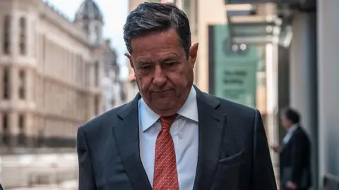 Ex-Barclays boss Jes Staley loses job ban tribunal case Getty Images Former Barclays boss Jes Staley wearing a suit with red dotted tie, walking outside