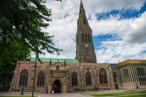 A preacher asked me out and then started stalking me An exterior of Leicester Cathedral, towering high in front of a lawn with a large tree on the left.