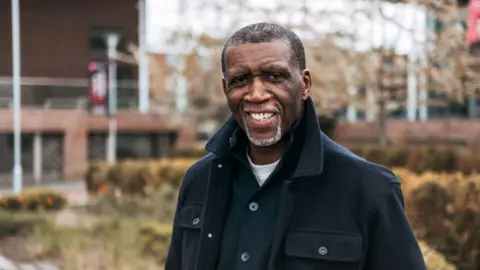 Government announces first Windrush commissioner PA Media Reverend Clive Foster smiles in a black jacket