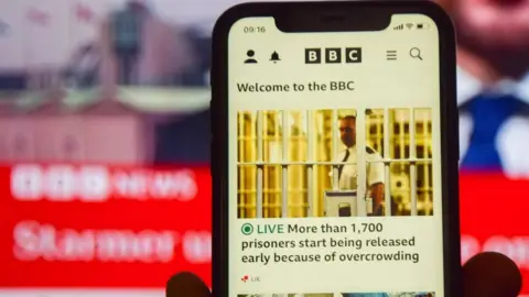BBC launches paywall in US for website and app Getty Images In this photo illustration, a BBC News website seen displayed on phone and TV screens