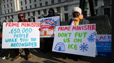 Scotland to recover winter fuel payment from better-off OAPs Getty Images Supporters and members of Age UK deliver a petition with over 650,000 signatures to Downing Street - they are holding signs saying things like Prime Minister, 650,000 people urge you to reconsider