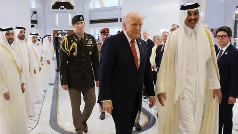 Did Trump really strike Gulf deals worth $2tn? Getty Images Trump walking with the Emir of Qatar Tamim bin Hamad al Thani