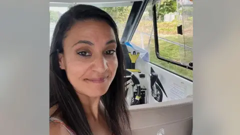 'I paid £15,000 then it went bust' Syreeta Sandhu Syreeta Sandhu smiles at the camera. She is in the driver's seat of a car