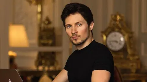 Telegram founder says he has fathered more than 100 children Pavel Durov/Instagram Tech billionaire Pavel Durov looks to the camera as he types on an Apple laptop. He is wearing a black t-shirt. There is an ornate clock in the background.