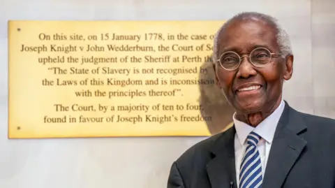 Sir Geoff Palmer, Scotland's first black professor, dies aged 85 PA Media Sir Geoff Palmer, wearing a suit, glasses and with white hair, stands alongside a plaque commemorating the historic Scottish slavery case, Knight v Wedderburn