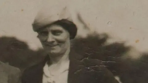 Avon and Somerset Police Louisa Dunne in a black and white photograph. She is wearing a hat and a brown jacket with a white shirt. 