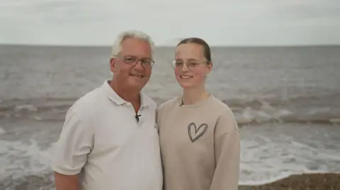 New drug offers potential cure for ultra rare inherited condition Jimmy Catchpole, with his daughter Mary, standing on a beach near their home in Norfolk.