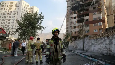 Israel's endgame may be regime change in Iran Getty Images firefighter stands in front of damaged building