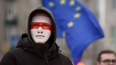 How Belarus dissidents in exile abroad are pursued and threatened Getty Images A man wears a mask bearing the colours of the historical flag of Belarus as he takes part in the March of Belarusians in Warsaw, Poland on January 26, 2025.