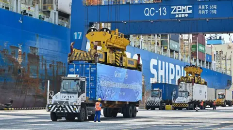 Tariffs prompt record plunge in US imports, cutting trade deficit China News Service/VCG via Getty Images Trucks transfer containers at Nansha Port on April 29, 2025 in Guangzhou, Guangdong Province of China. G