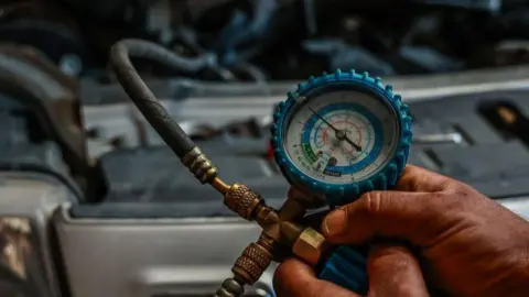 Why we need 'revolutionary' cooling tech Getty Images A pressure gauge is used to check the refrigerant levels in a car's air conditioning