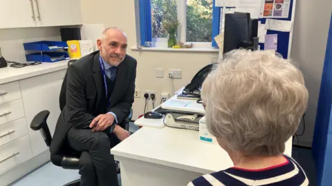 Behind the scenes at a GP 8am scramble Dr Jonathan Lloyd a GP partner holding a consultation with a patient in his surgery