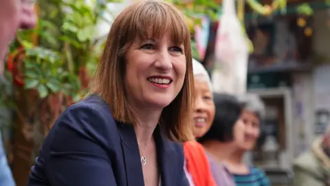 Shaping Scotland's priorities for years to come PA Media Rachel Reeves, a smiling woman in a blue jacket with red straight hair is sitting in what appears to be a beer garden talking to someone off camera. Some other women can just be made out in the out of focus background.