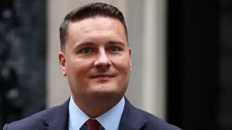 No budget for assisted dying service, health secretary says EPA Health Secretary Wes Streeting stands outside 10 Downing Street, wearing a blue shirt and a navy suit