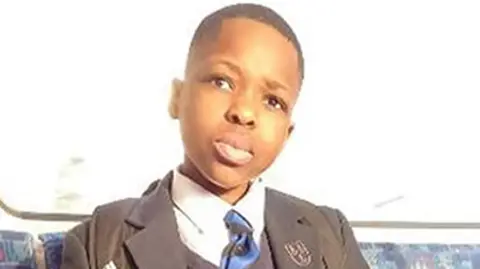 Hainault sword attacker jailed for life for murdering schoolboy Metropolitan Police handout Daniel Anjorin, a teenager with short dark hair and wearing a school uniform with a blue striped tie sits on a train