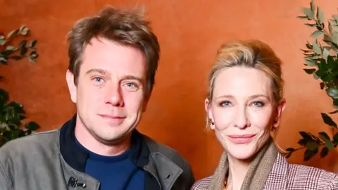 NI-born designer Jonathan Anderson becomes fashion brand's creative director Getty Images Jonathan Anderson and actress Cate Blanchett attended at a Vogue runway show in London in November. Anderson is wearing a grey jacket and blue sweater, Blancett has her hair up and is wearing a brown scarf and brown checked suit jacket