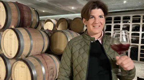 Winemakers finding Trump's tariffs hard to swallow Winemaker Cecile Tremblay holds a glass of red wine in her cellar