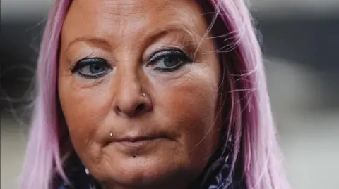 Harry Dunn police 'could and should have arrested' diplomat Aaron Chown/PA Images Woman with a tan and purple tinted hair. She appears solemn and is looking off camera.