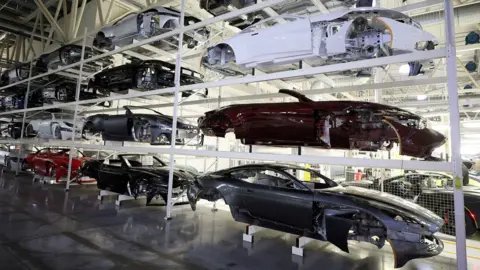 UK car production fell to 76-year low in May as US tariffs hit trade Reuters Car bodies are stored on shelves at the Aston Martin factory in Gaydon, Britain