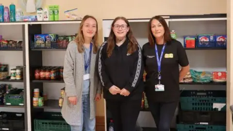 North Shields social hub helps care-experienced people gain skills North Tyneside Council Rachel Fairless is standing in the middle of the pantry with two other women. Behind them are shelves filled with pantry food and tins.