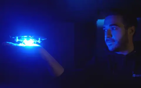 Will they overtake firework displays? Skymagic Patrick O'Mahony looks at a drone sitting in his hand, lit up by a blue LED light.