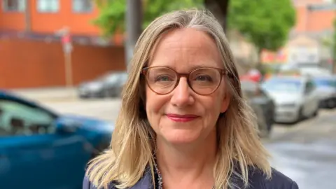 Food makes up majority of NI household spending Philippa McKeown-Brown. She has shoulder-length blonde hair, wearing glasses and a navy jacket.