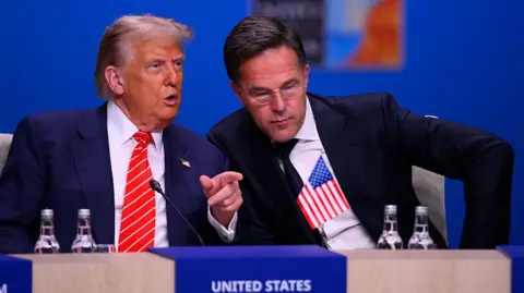 Nato agrees spike in defence spending and stresses 'ironclad' security guarantee JOHN THYS/AFP US President Donald Trump (L) in a blue suit speaks to NATO Secretary General Mark Rutte in a darker suit and leaning towards him at the start of a NATO leaders summit in The Hague,