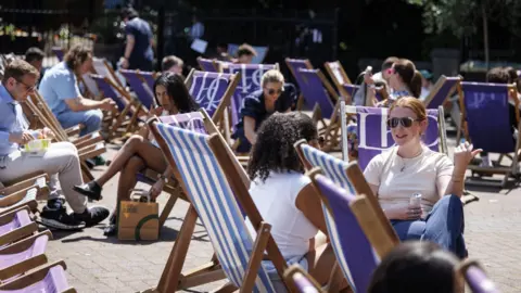 Temperatures surpass 29C as UK heads for heatwave EPA-EFE/Shutterstock People sit on deckchairs during sunshine in London