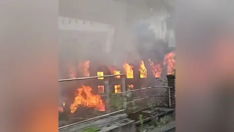 Residents evacuated from tower as blaze spreads Catherine Adams Fire engulfs an old mill building in Manchester. Huge plumes of resulting smoke are visible across the city.