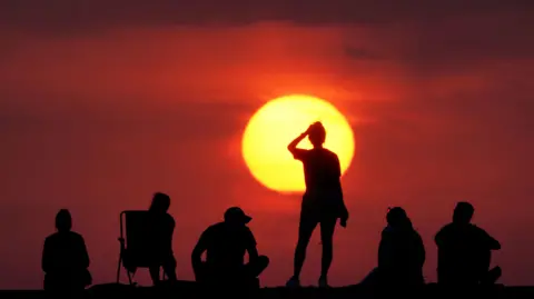 Temperatures surpass 29C as UK heads for heatwave PA Media People turning out to watch the sunrise at Cullercoats Bay, North Tyneside