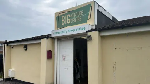 Big Venture Centre stepping in where 'everyone is struggling' The Big Venture Centre is a single-storey yellow building. Some of the paint has chipped away. One of its white doors also looks like a little old and tired. The sign says: Big Venture Centre. Community Shop Inside.