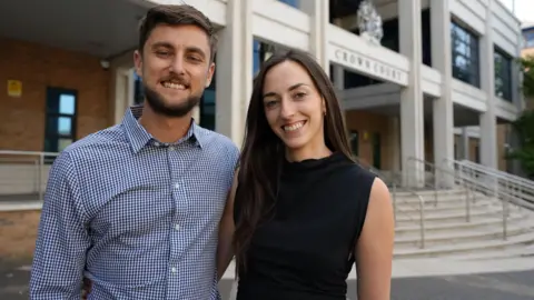Wandsworth neighbour jailed for doorbell camera abuse and threats Ben, a man with brown hair and a short beard wearing a shirt, and Emma, a woman with long dark hair and wearing a black sleeveless top, outside court