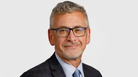 Dundee University bosses quit after damning report into financial collapse University of Dundee Prof Shane O'Neill is smiling in a university website picture. He has grey hair and beard and is wearing dark glasses, a dark jacket and grey shirt and tie