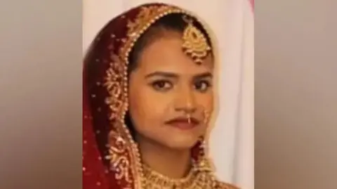 Habibur Masum admits killing wife as she pushed pram in Bradford Handout Woman looks at camera while clothed in a sari and wearing lots of gold jewellery on her face and neck