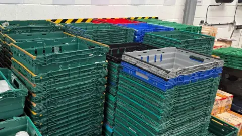 Lincoln food bank at 'breaking point' due to low stock BBC News The photo shows towers of different coloured empty crates stacked on top of each other. Each stack contains 15 to 20 crates.