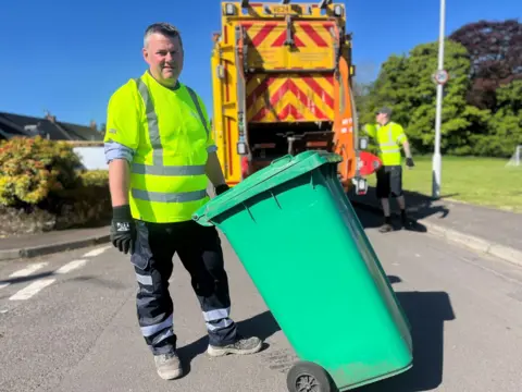 Truckloads of Scotland's rubbish will be exported to England, say experts Disclosure reporter Kevin Keane about to load a green bin onto the refuse lorry while out on a collection with workers in Fife.