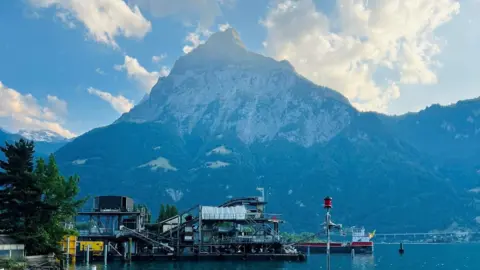 Scottish wingsuit flyer dies during Swiss Alps jump Byrne family Mountain - Gitschen mountain - in Switzerland, with water in the foreground.