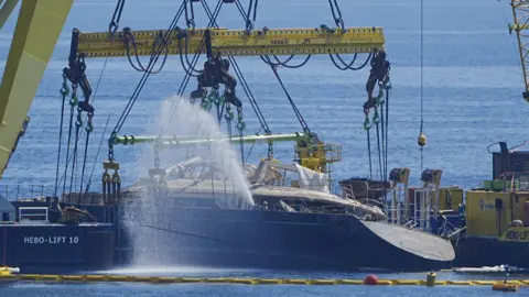 Sunken British superyacht raised from seabed Peter Byrne/PA Wire Water being pumped out of the ship - its name can be seen very faintly