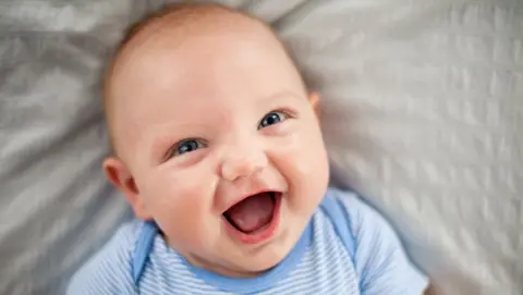 Wollaston charity supports one in 16 babies across the county Getty Images A file photo of a smiling baby with very short hair, wearing a blue and white outfit and lying on a grey sheet