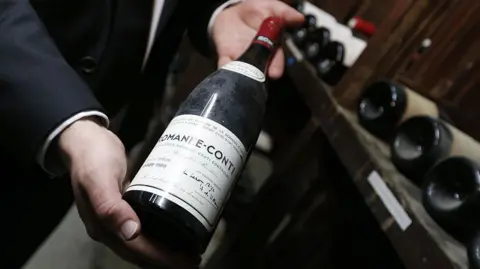 Winemakers finding Trump's tariffs hard to swallow Getty Images A man holding a bottle of very expensive red Burgundy