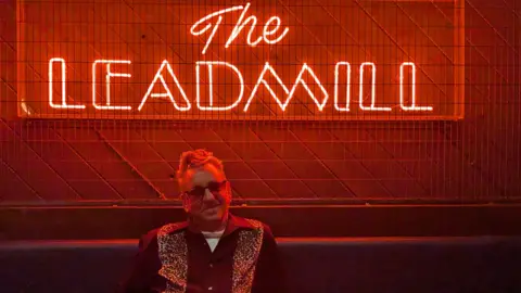 Fans and musicians share memories of Sheffield's The Leadmill Richard Hawley sat under a red neon light which reads 'The Leadmill'