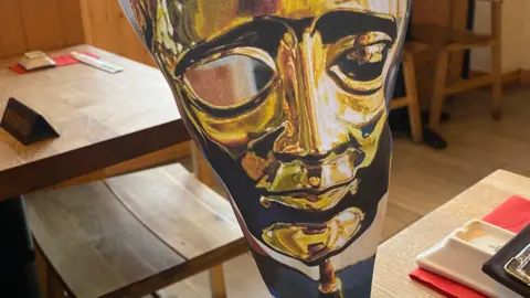 The dark comedy inspired by 'bleak' dating scene Lizzie Davidson A mock Bafta award made of paper, on a wooden table inside an empty restaurant.