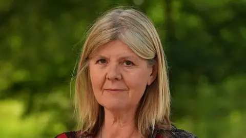 Sizewell C nuclear plant gets £14.2bn government investment Martin Giles/BBC Stop Sizewell C director Alison Downes outside in Suffolk. She has shoulder length blonde hair.