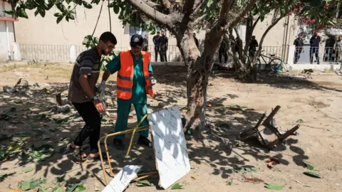 Three journalists among five killed in Israeli strike on Gaza hospital Reuters Palestinians inspect damaged furniture after an Israeli strike on the compound of al-Ahli hospital, in Gaza City (5 June 2025)